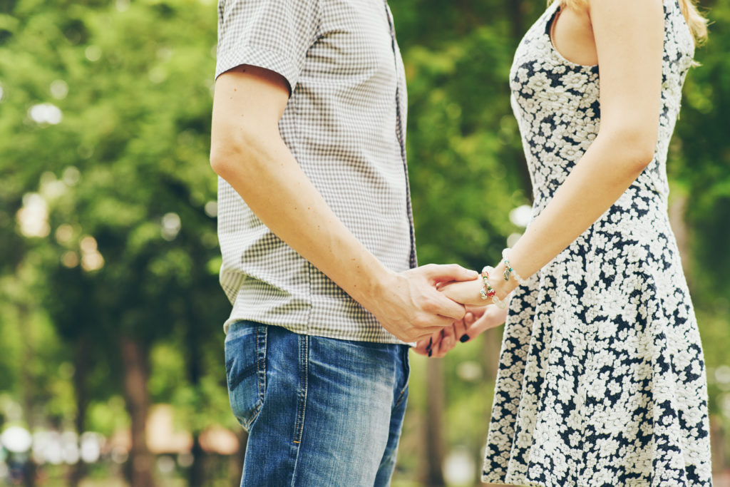 Cropped image of couple in love holding hands