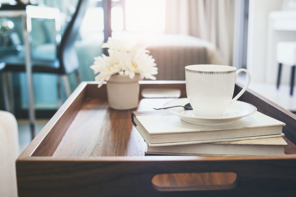 Home Interior with Coffee cup Book white flower on table wooden tray Hipster lifestyle background